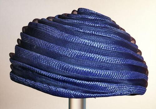 Ronde donkerblauwe dameshoed zonder rand, spiraalvormige opbouw van banen gaas en stro, raffiaen…