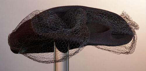 Baret van bruin vilt in a-symmetrische vorm met voile garnering