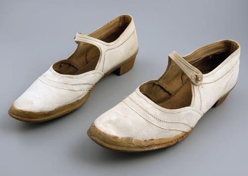 Witte linnenzomerschoenen met bruine rubbern zool en wreefbandje met knoopsluiting