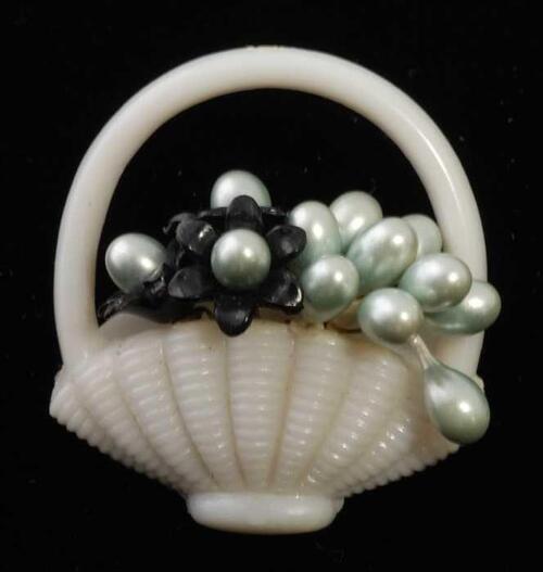 Broche van wit plastic, hengselmand met kunstbloemetjes, kapper Van Vliet