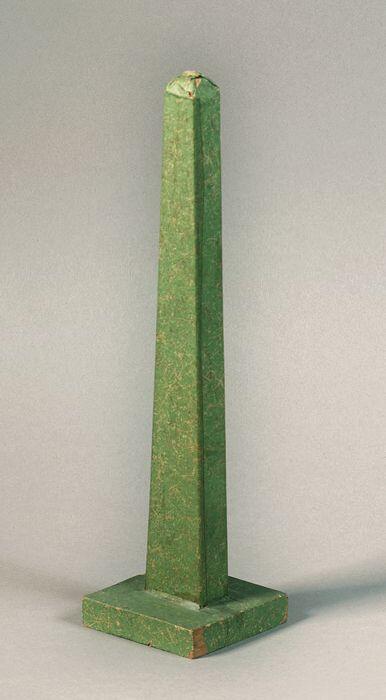 Hoedenstandaard, obelisk vorm van hout beplakt met groen papier, verzwaard met lood