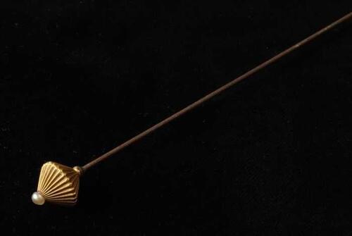 Hoedenspeld, lange metalen pin met scherpe punt, goudkleurige metalen knop, op de top een kleine…