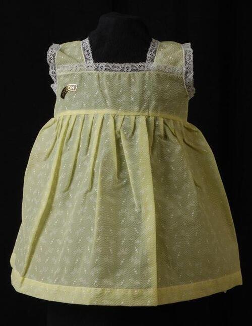 Babyjurk, mouwloos schortmodel van transparant geel nylon 'Femifra'