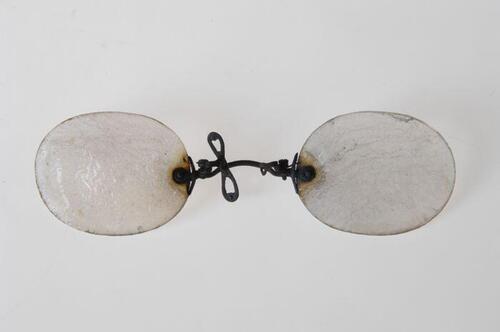 Pince-nez met glazen aan verend klemmende neusbrug, uit de brand van 14 mei 1940 afkomstig