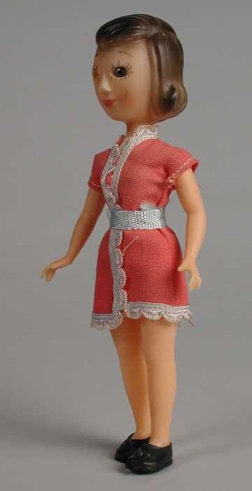 Kleine pop van roze gekleurd plastic, gekleed in roze jurkje, reclame-uitgave Biotex