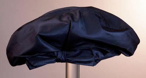 Baret, donkerblauwe zijde voor geplooid met plat strik, metalen hoedenspeld met knop van identieke…