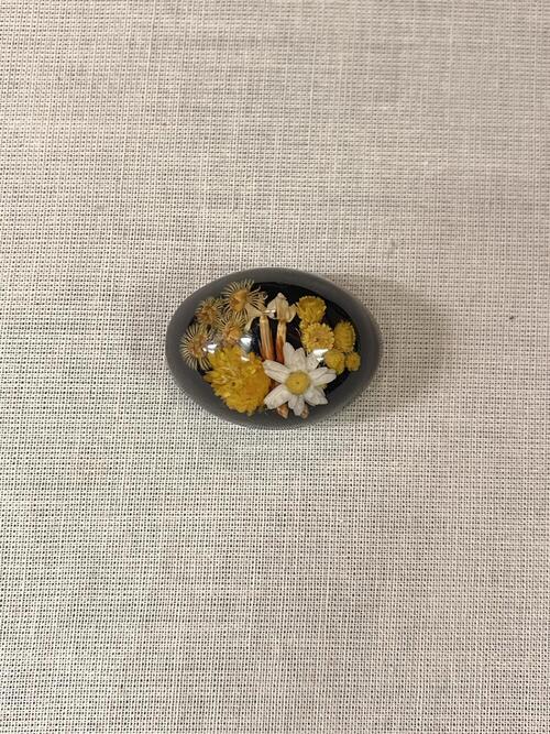 Broche met bloemen, gegoten kunststof, ovaal-vormig, bruine ondergrond met gele en witte bloemen