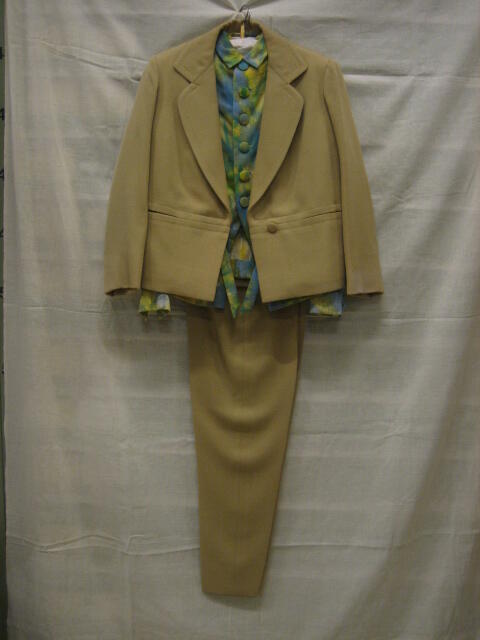 Ensemble van beige wollen serge,  bestaande uit jasje, lange broek en blouse, de blouse bedrukt met…