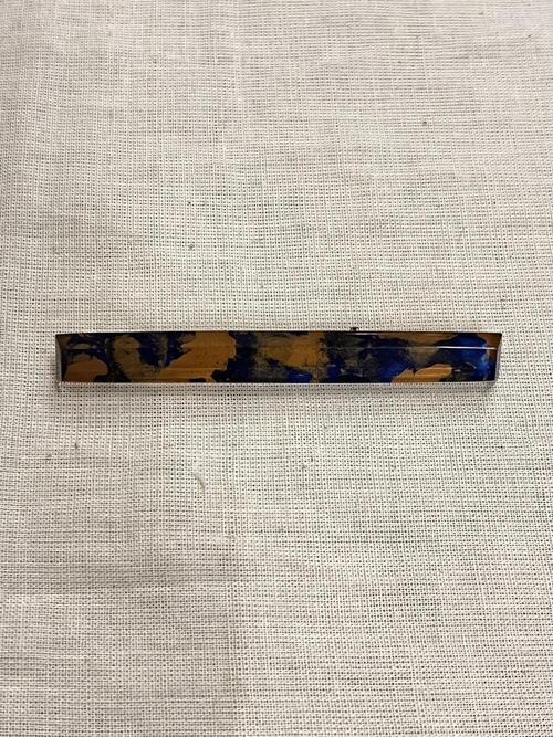 Broche, langwerpige staaf-vorm, koperkleurig en blauw 'wolkerig' effect met doorzichtig kunststof