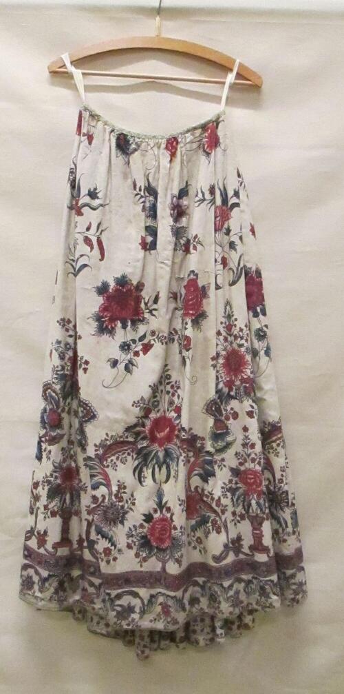 Rok van witte sits, beschilderd met dessin van bloemen en vaasvormen, in blauw, rood en lila