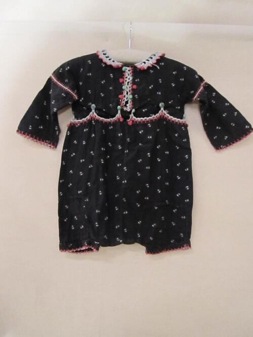 Peuterpakje bestaande uit blouse en broek van zwart flanel met roze bloemetjes