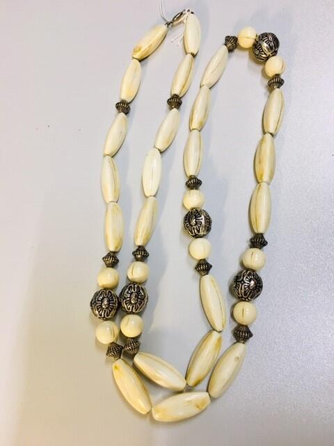 Ketting. Plastic, imitatie been langgerekte kralen en imitatie zilveren kralen. Lang snoer