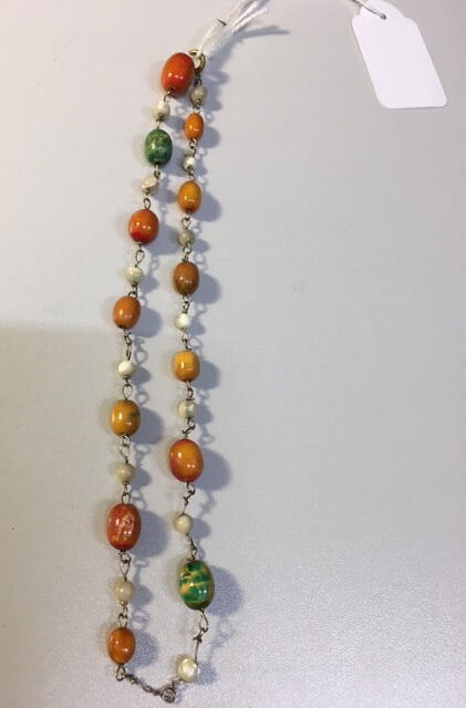 Kinderketting, ovoïde kunststofkralen in afwisselend melkwit en oranje- en/of groentinten, aan…
