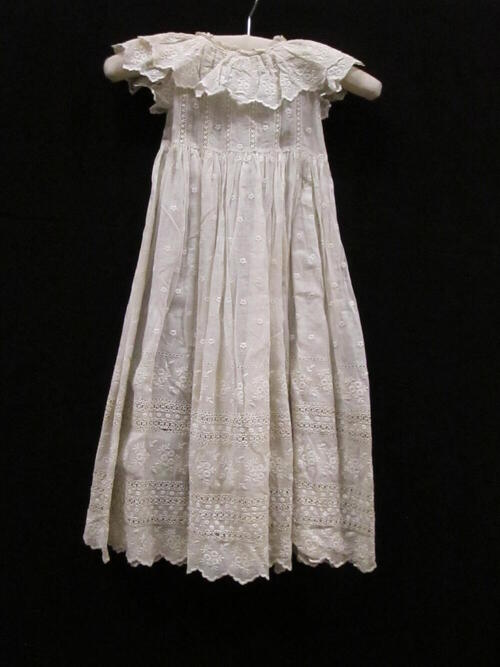 Jurk (kind) van batist, broderie en borduursel of kant / Draagjurk van wit batist, gegarneerd met…