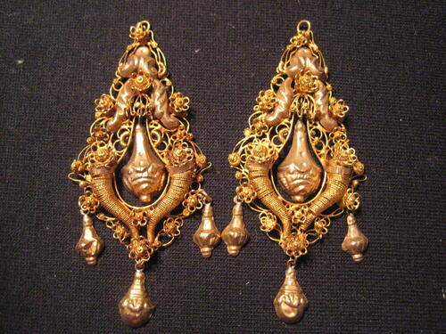 1 paar gouden oorhangers. Peervormige ornamenten van filigrain, ondergedeelte met 2 hoorns des…
