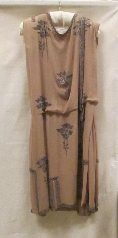 Avondjurk van beige crêpe georgette, asymmetrisch kralenborduursel in roosmotieven op voor- en…