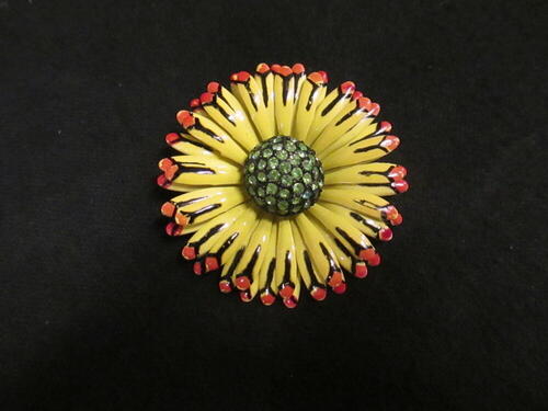 Broche in vorm van zonnebloem, bladeren van geel/rood/zwart geëmailleerd metaal, hart van zwart…