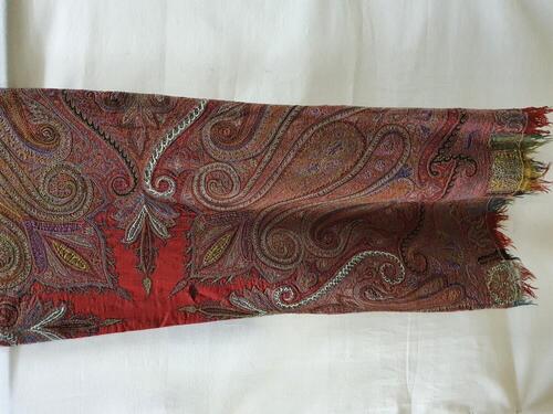 Shawl van rode wol met veelkleurig borduursel en applicaties van zwarte en witte wollen stof