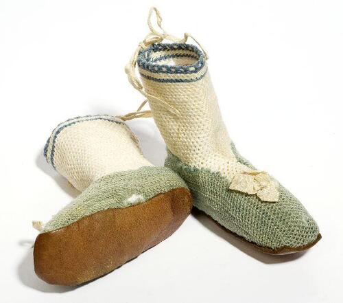 Een paar slofjes voor een baby, turqoise en witte wol met leren zool