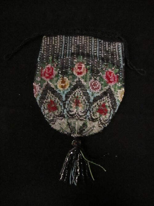 Reticule, geheel bewerkt met veelkleurige kraaltjes in bloemranden. Kralenkwast aan de onderpunt