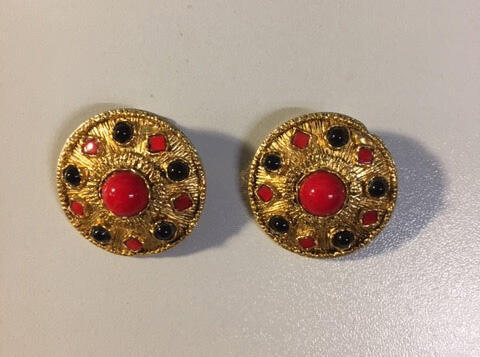 Oorclips, cirkelvormig model van goudkleurig metaal in straalreliëf, ingelegd met rode en zwarte…