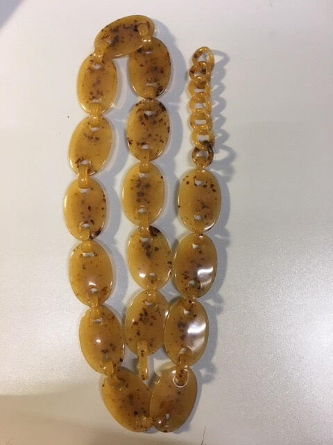Ceintuur van imitatieschildpad (oranje kunststof met bruine 'insluitsels'), opgebouwd uit…