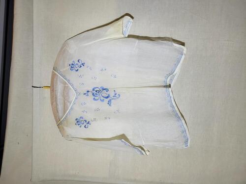 Blouse van dun wit katoen, geborduurd met blauwe zijde, schoudersluiting middels witte knoopjes van…