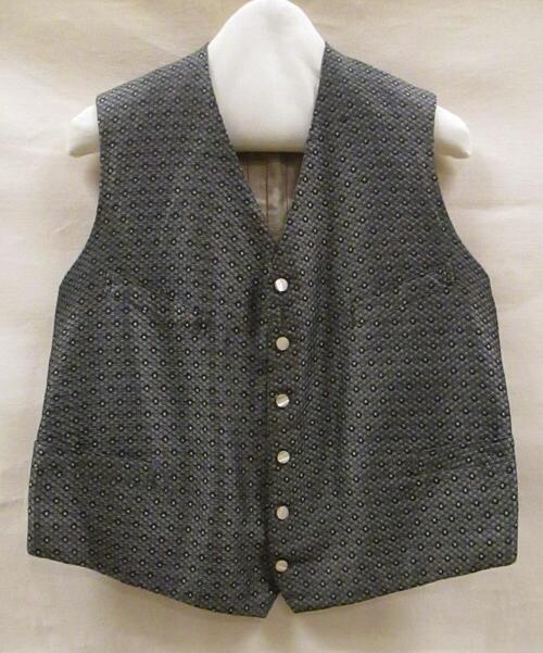 Vest (man) van zwart/witte zijde, geweven in zeshoekig motief met paarse stippen, achterpand van…
