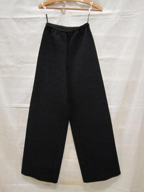 Lange broek van zwarte, gemengde wol met ingeweven horizontale ribbels, onderdeel van…
