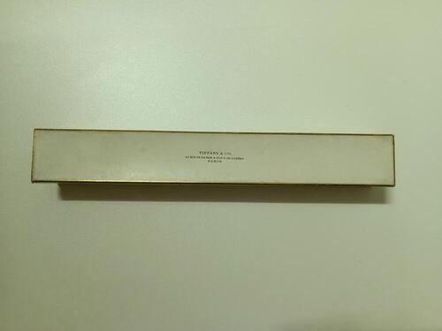 Waaierdoos van wit karton met goudkleurige rand, bovenop deksel logo Tiffany & Co