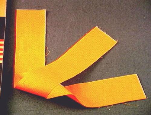 Een oranje mousseline doek, onderdeel van een vijfdelige kledingset van een noviet.