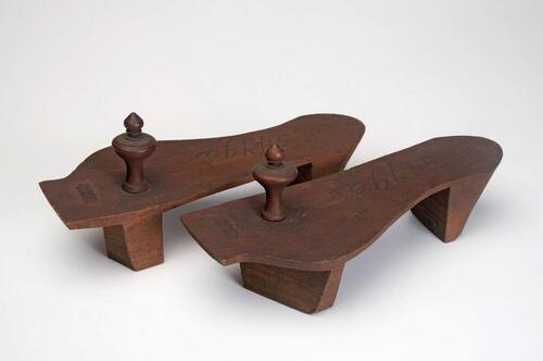 Een paar houten slippers met houten knoppen