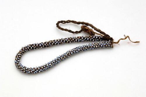 Necklace of plaited fibers with beads