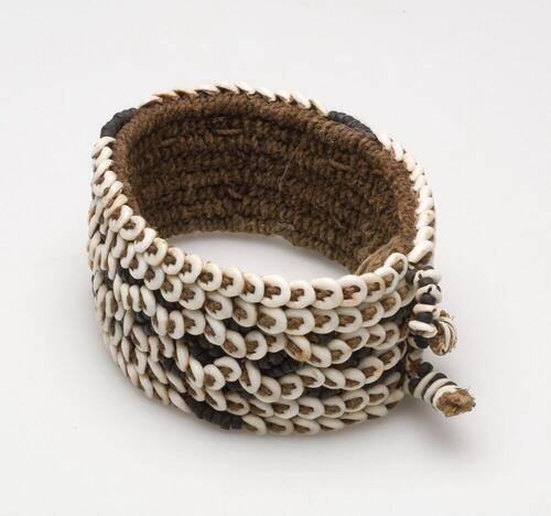 Armband van gevlochten touw met versiering van nassaschelpjes en vruchtschalen