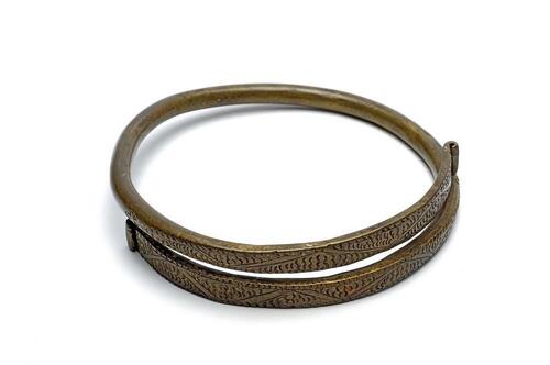 Messing armring versierd met ingegrifte figuren
