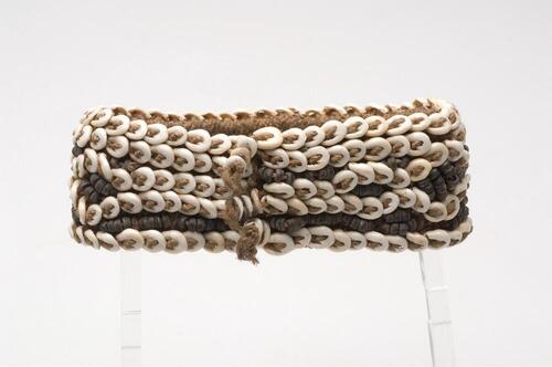 Armband gevlochten van plantenvezels, versierd met pitten en nassa-schelpen