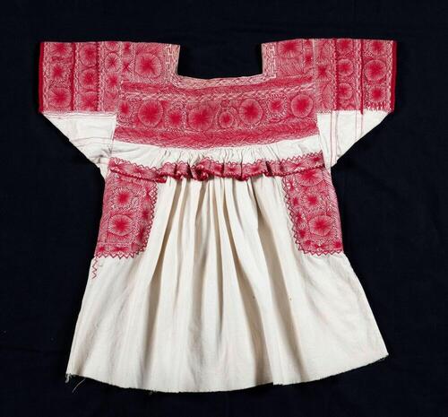 Witte blouse met rode versieringen