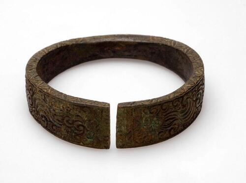 Bronzen armband met vlam- en krulmotieven