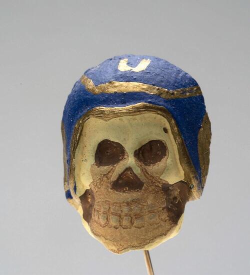 Kledingspeld in de vorm van een doodshoofd met motorhelm, vervaardigd voor Allerzielen