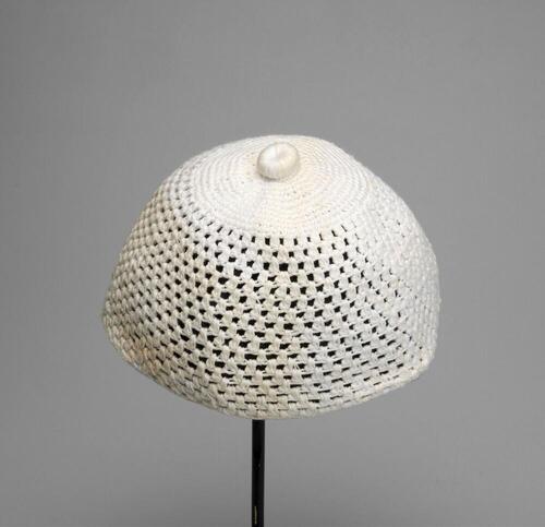 Witte gehaakte muts met platte, ronde knoop