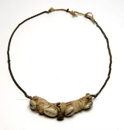 Halsketting met schelpen en belletjes, die tevens dient als amulet