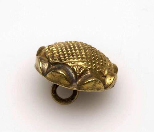 Gouden knoop voorzien van geblokt kussen