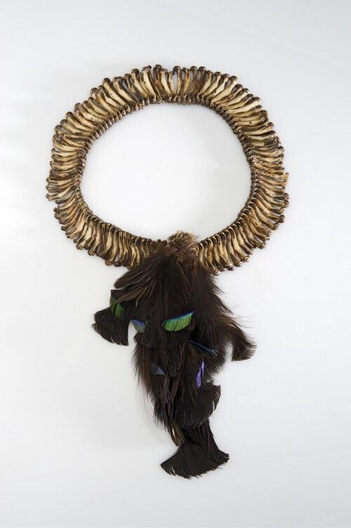 Head ornament made of cuscus bones with feathers, worn by man