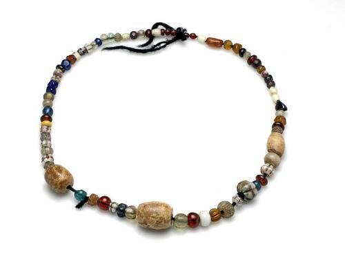 Kralensnoer met 75 prehistorische kralen van glas en steen in verschillende vormen en kleuren,…