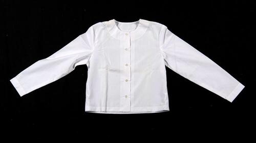 Een witte katoenen blouse, onderdeel van een driedelige kledingset van een non.