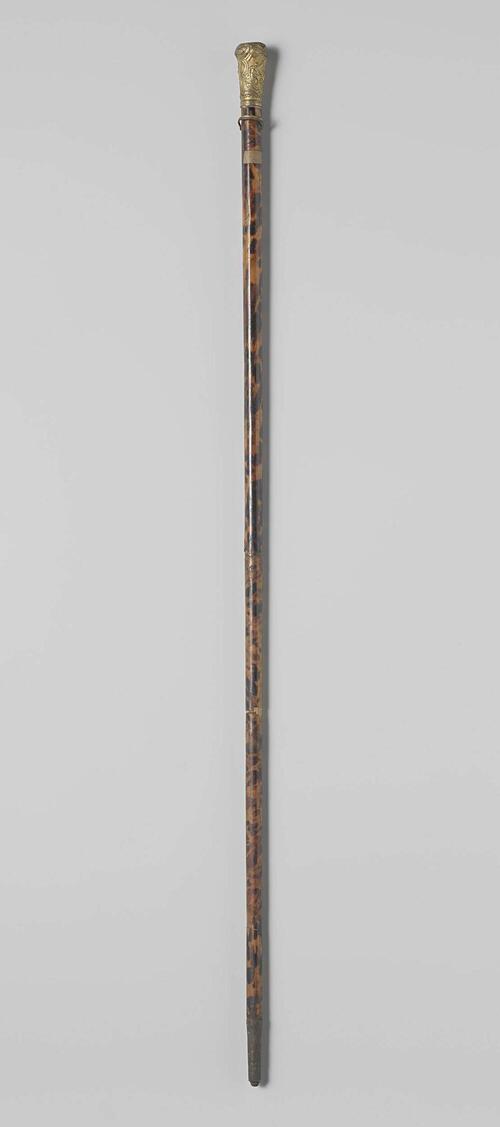 Wandelstok van hout waaromheen schildpad en waarop een vergulde knop, versierd met mythologische…