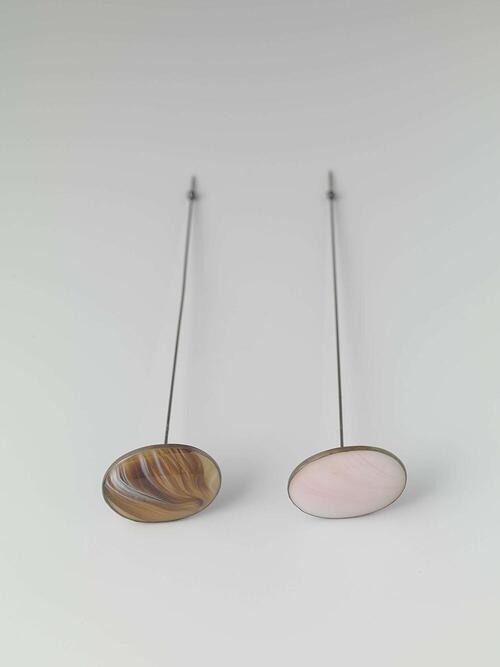 Hoedenspeld van metaal met platte, ovale knop waarin gemarmerd bruin/beige/wit glas