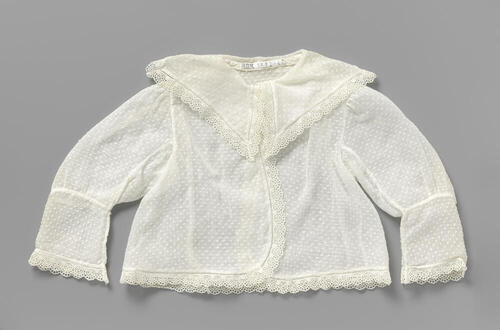 Grof batisten babyjas met ingeweven nopjes en afgezet met een smalle rand broderie