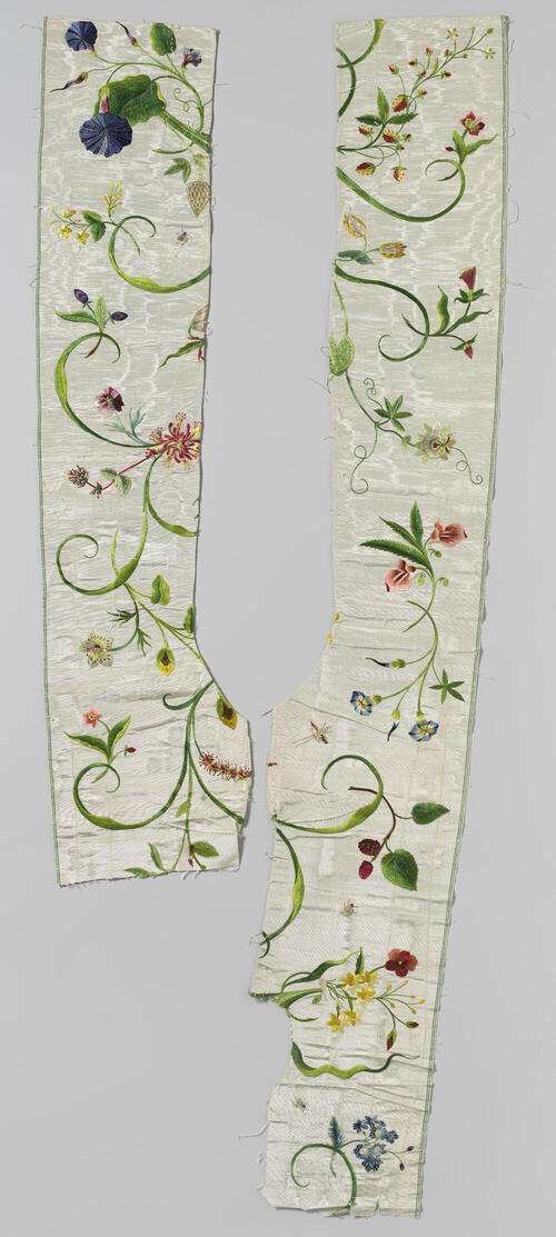 Fragment van een japon van witte moirézijde, rijk geborduurd met bloemranken in veelkleurige zijde