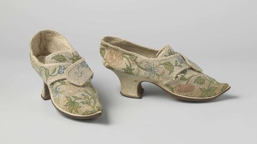Schoen met blad, tong en flappen van linnen, in petit point geborduurd met floraal motief van…
